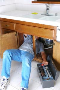 Plumber repairs a kitchen sink drain